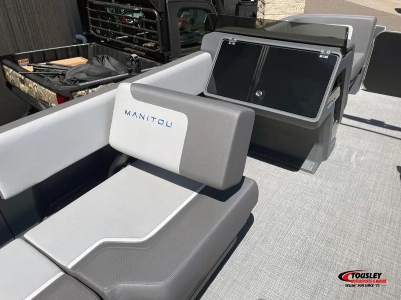 Slide: The Image of 2025 Manitou Cruise 22 Switchback Twin Tube boat interior with gray seating and dashboard. - 13