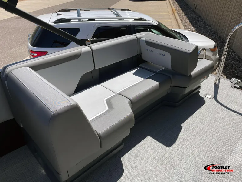 Slide: The Image of 2025 Manitou Cruise 22 Switchback Twin Tube boat seating, gray upholstery, outdoor setting. - 3
