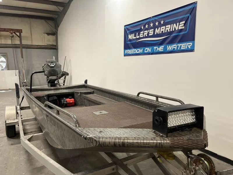 Slide: The Image of 2025 Gator Tail 1750 Savage Mid Deck boat on trailer in showroom. - 2