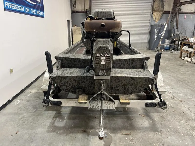 Slide: The Image of 2025 Gator Tail 1750 Savage Mid Deck boat in a garage, rear view. - 4