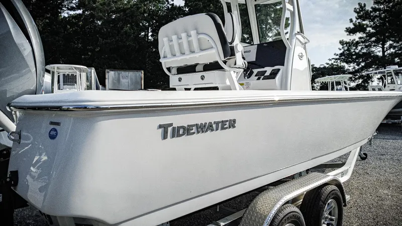 Slide: The Image of 2026 Tidewater 2410 Bay Max boat on trailer, side view with trees in background. - 13
