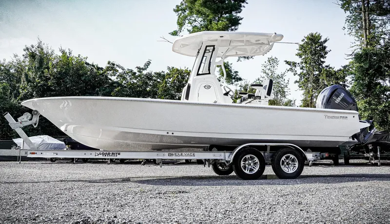 Slide: The Image of 2026 Tidewater 2410 Bay Max boat on trailer, parked outdoors. - 2