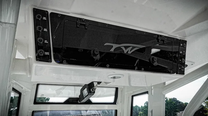 Slide: The Image of 2026 Tidewater 2410 Bay Max boat interior with control panel and storage compartment. - 21
