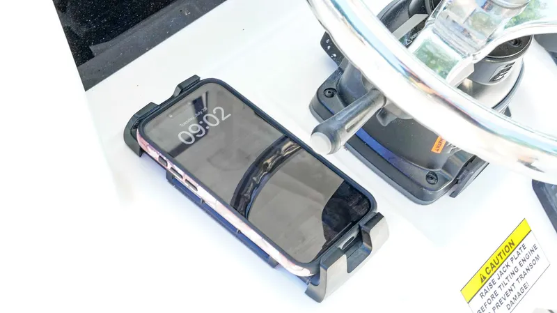 Slide: The Image of Smartphone on Tidewater 2410 Bay Max boat dashboard, near steering wheel, displaying time 09:02. - 29