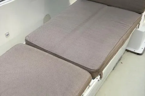 Slide: The Image of 1977 Aquasport 222 boat interior with cushioned seating in neutral tones. - 14