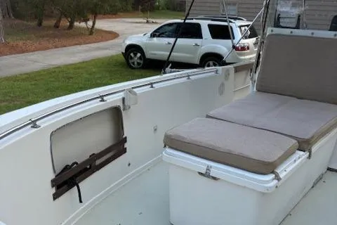 Slide: The Image of 1977 Aquasport 222 boat interior with cushioned seating, parked SUV in background. - 3