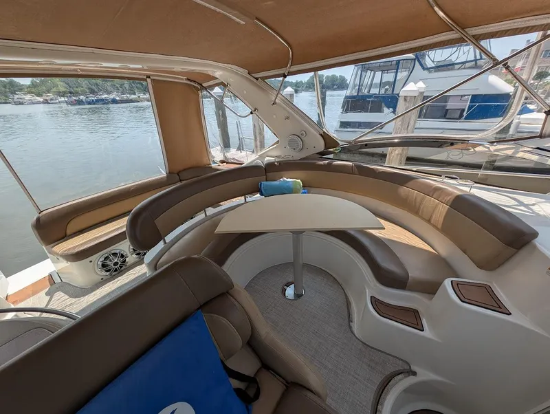 Slide: The Image of Interior of 2002 Regal Commodore 3860 yacht with curved seating and table, docked by water. - 18