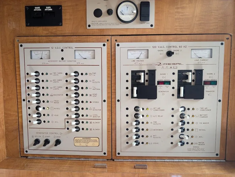 Slide: The Image of Electrical control panel of a 2002 Regal Commodore 3860 boat, featuring switches and gauges. - 24