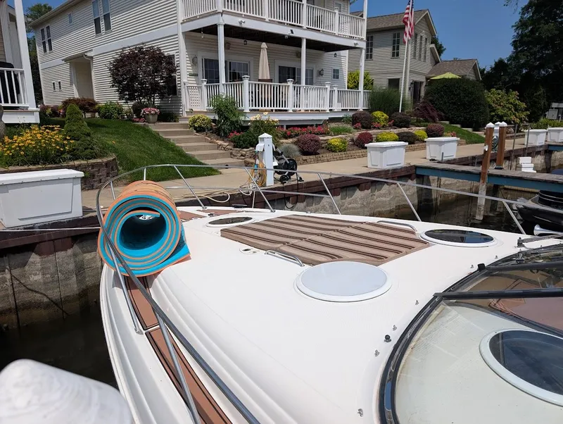 Slide: The Image of 2002 Regal Commodore 3860 yacht docked near a waterfront home with garden. - 3