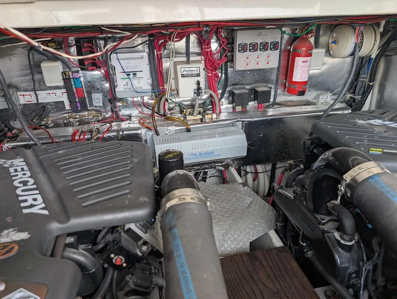 Slide: The Image of Engine room of a 2002 Regal Commodore 3860 with Mercury engines and electrical components. - 42
