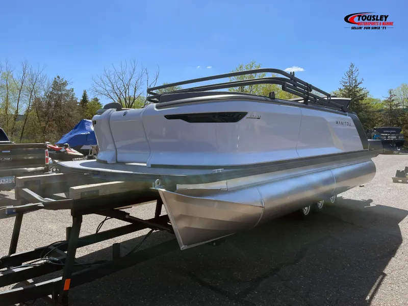 Slide: The Image of 2025 Manitou Cruise 20 MAX Bench Twin Tube pontoon boat on trailer, outdoors. - 6