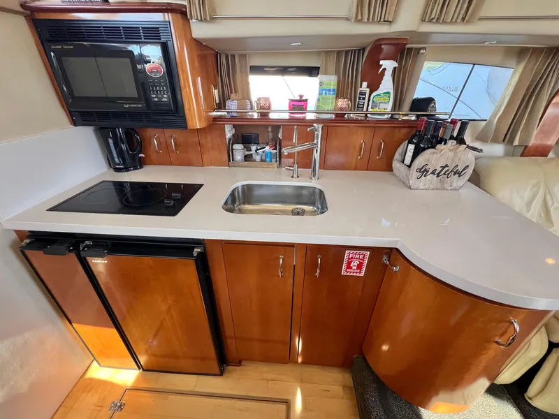 Slide: The Image of 2004 Carver 420 Mariner kitchen with microwave, stove, sink, and wooden cabinetry. - 20