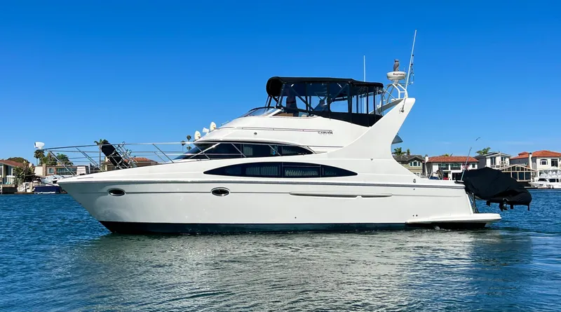 Slide: The Image of 2004 Carver 420 Mariner yacht on calm water, clear blue sky background. - 3