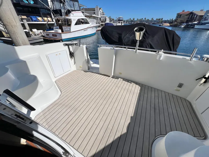 Slide: The Image of 2004 Carver 420 Mariner boat deck with wood flooring, docked in a marina. - 10