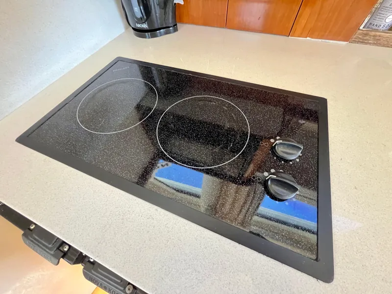 Slide: The Image of Ceramic cooktop in 2004 Carver 420 Mariner yacht kitchen, featuring two burners and control knobs. - 23