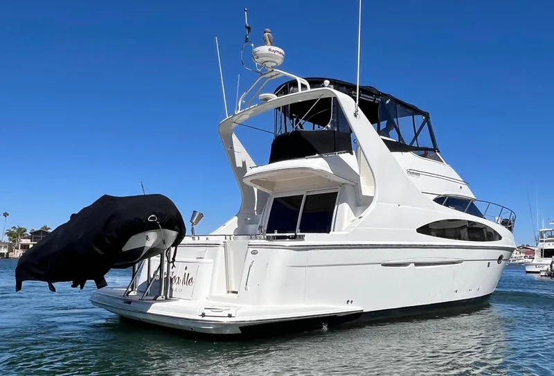 Slide: The Image of 2004 Carver 420 Mariner yacht on water, featuring sleek design and covered upper deck. - 4