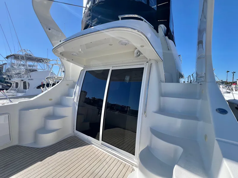 Slide: The Image of 2004 Carver 420 Mariner yacht with sleek design and dual staircases, docked under clear blue sky. - 9