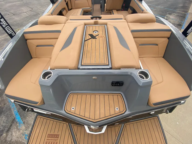 Slide: The Image of 2022 MasterCraft XStar boat interior with tan seating and teak accents. - 3