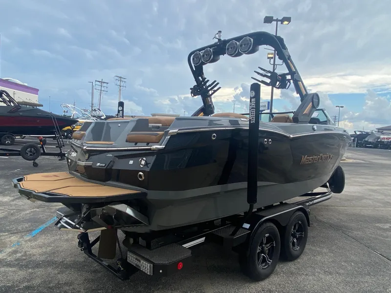 Slide: The Image of 2022 MasterCraft XStar boat on trailer, sleek design, outdoor display. - 6