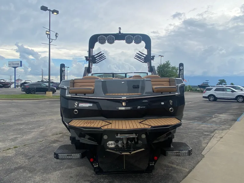 Slide: The Image of 2022 MasterCraft XStar boat, rear view, parked outdoors under cloudy sky. - 7