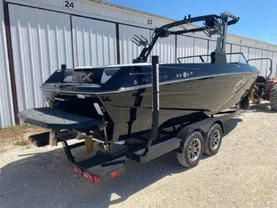 Slide: The Image of 2025 ATX Surf Boats 24 Type-S, black, on trailer, parked outdoors. - 4