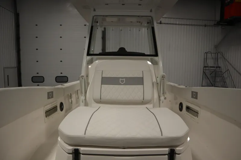 Slide: The Image of 2026 Sea Fox 268 Commander boat interior with white cushioned seating in a showroom. - 22