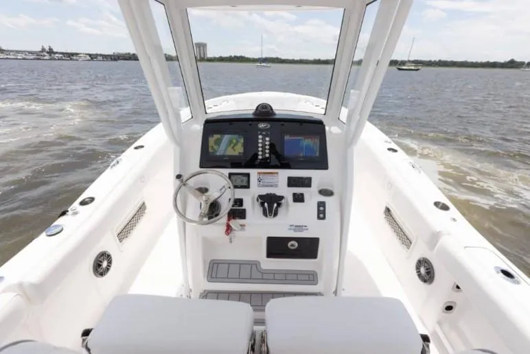 Slide: The Image of 2026 Sea Fox 268 Commander boat dashboard with steering wheel and navigation screens on open water. - 92