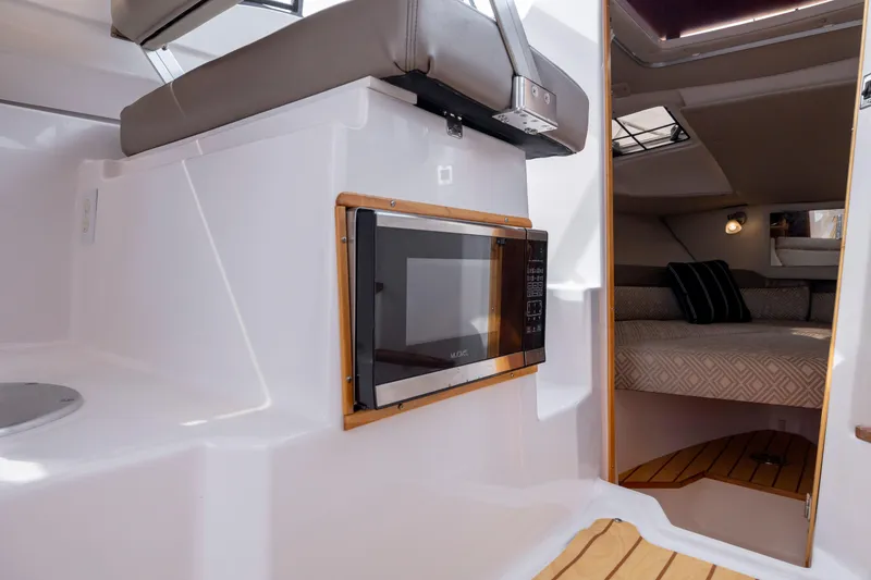 Slide: The Image of 2020 Cutwater C-24 interior with microwave and cozy cabin bed. - 11