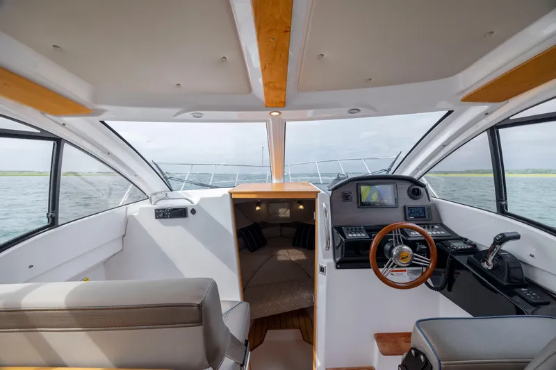 Slide: The Image of 2020 Cutwater C-24 boat interior with helm, seating, and cabin view. - 12
