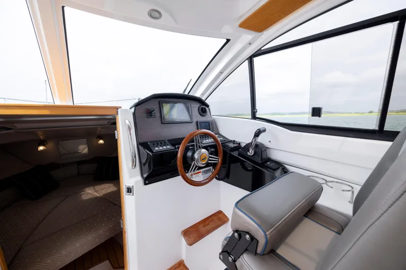 Slide: The Image of 2020 Cutwater C-24 boat interior with helm, steering wheel, and cabin view. - 14