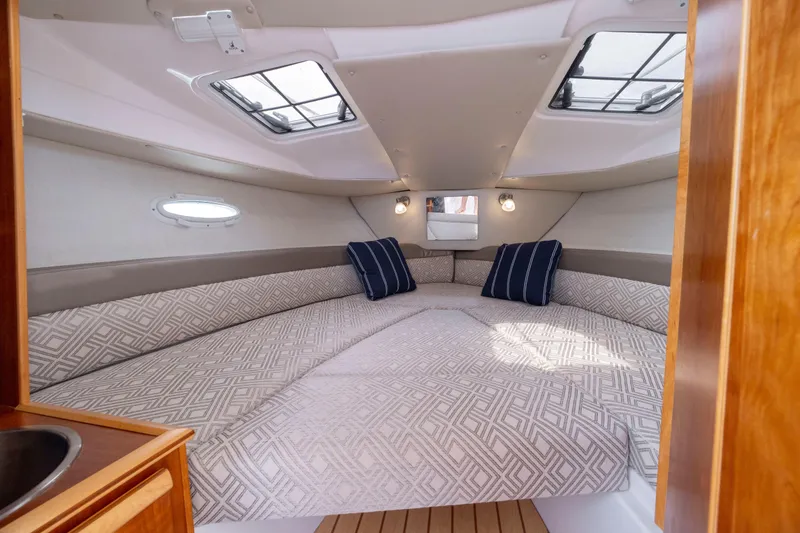Slide: The Image of 2020 Cutwater C-24 cabin interior with patterned bedding and skylights. - 19