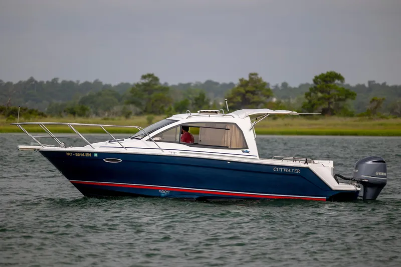Slide: The Image of 2020 Cutwater C-24 boat on water, side view with Yamaha outboard motor. - 2