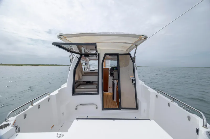 Slide: The Image of 2020 Cutwater C-24 boat with open cabin door on calm water. - 23