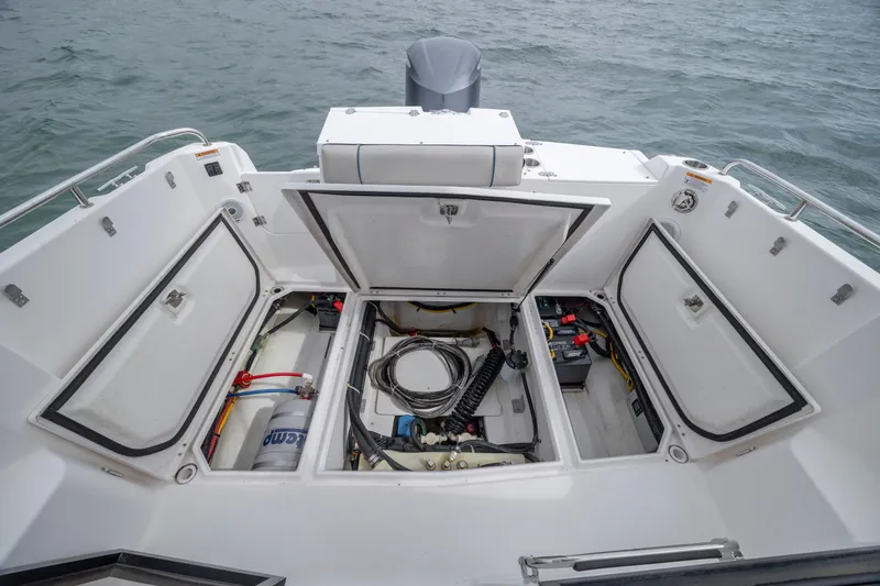 Slide: The Image of 2020 Cutwater C-24 boat storage compartments open, revealing equipment and wiring. - 27