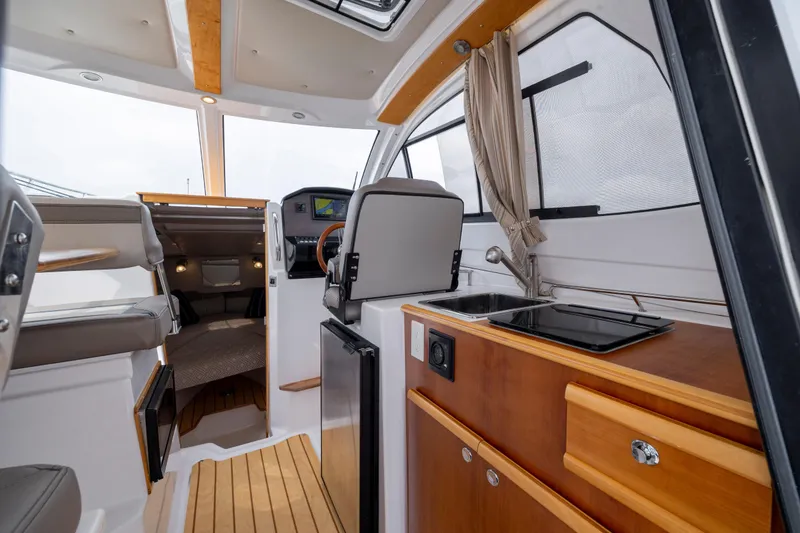 Slide: The Image of Interior of 2020 Cutwater C-24 boat featuring helm, kitchenette, and seating area. - 8