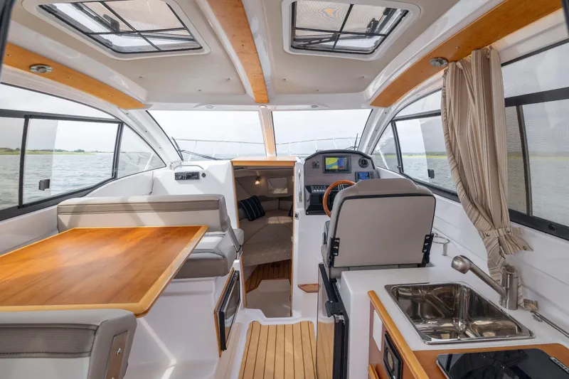 Slide: The Image of Interior of 2020 Cutwater C-24 boat, featuring seating, table, and helm with navigation equipment. - 9