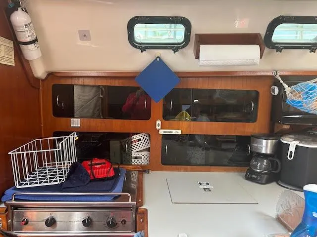 Slide: The Image of 1987 Hunter 35 yacht interior kitchen with stove, storage, and appliances. - 27
