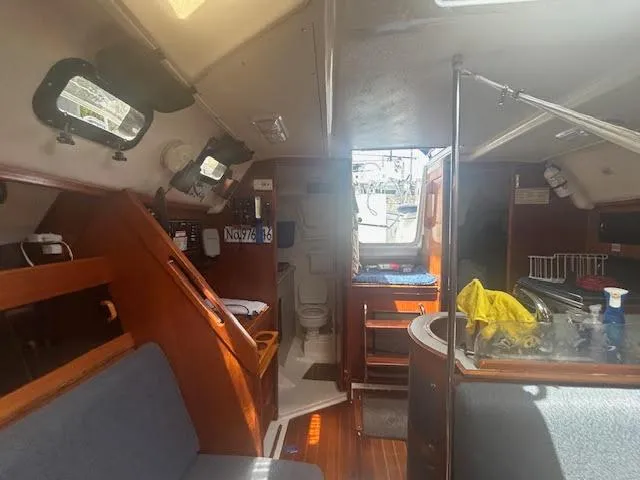 Slide: The Image of Interior of a 1987 Hunter 35 sailboat, featuring a cozy cabin with seating and a small kitchen area. - 30