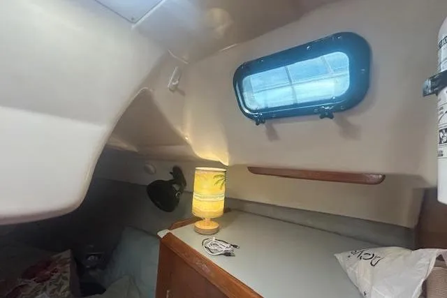 Slide: The Image of Cozy cabin interior of 1987 Hunter 35 sailboat with lamp and porthole window. - 32