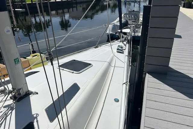 Slide: The Image of 1987 Hunter 35 sailboat docked by a calm waterfront. - 36