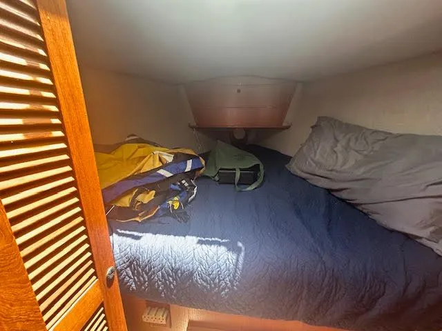 Slide: The Image of Cozy cabin interior of 1987 Hunter 35 sailboat with bedding and storage. - 37