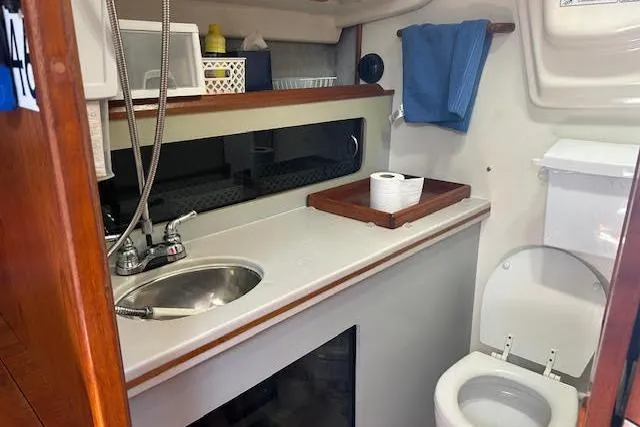 Slide: The Image of 1987 Hunter 35 yacht bathroom with sink, toilet, and storage shelves. - 41