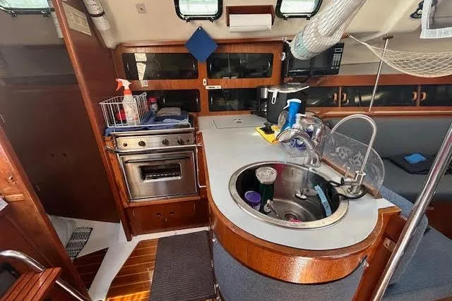 Slide: The Image of 1987 Hunter 35 sailboat interior kitchen with stove, sink, and storage. - 44