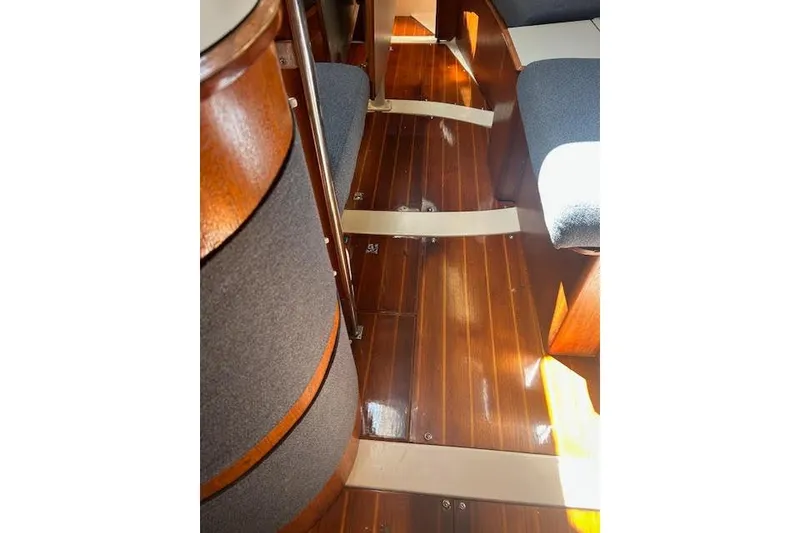 Slide: The Image of Interior of 1987 Hunter 35 sailboat with polished wooden flooring and cushioned seating. - 55