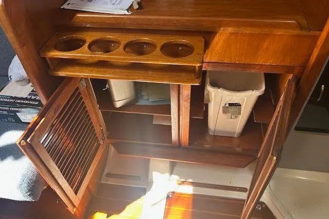 Slide: The Image of 1987 Hunter 35 yacht interior with wooden cabinetry and storage compartments. - 56