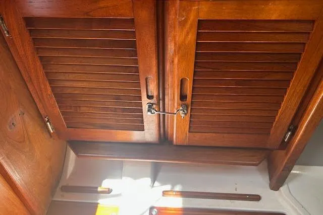 Slide: The Image of Wooden cabinet doors inside a 1987 Hunter 35 sailboat, showcasing classic nautical design. - 57