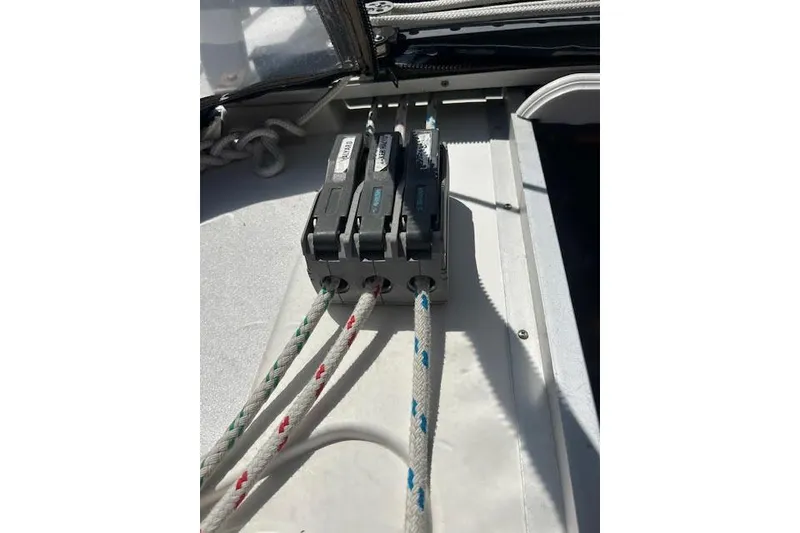 Slide: The Image of Rope clutches on a 1987 Hunter 35 sailboat deck, securing colorful ropes. - 60