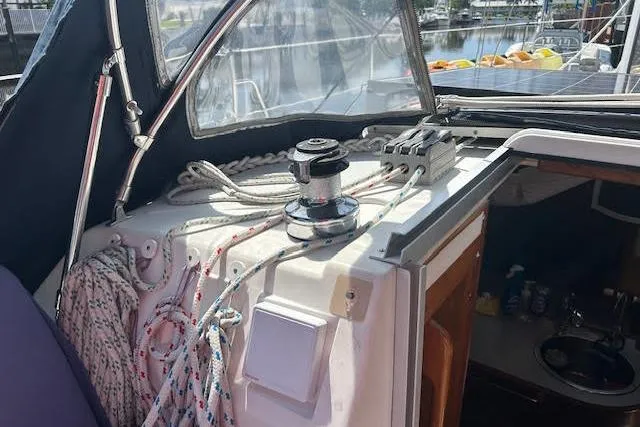 Slide: The Image of 1987 Hunter 35 sailboat cockpit with winch, ropes, and cabin entrance. - 63