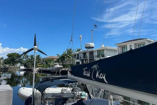 Slide: The Image of 1987 Hunter 35 sailboat docked near waterfront homes under clear blue sky. - 72