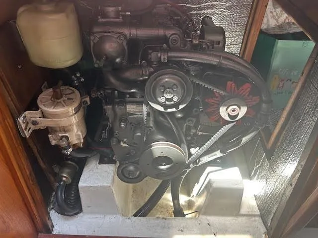 Slide: The Image of Engine compartment of a 1987 Hunter 35 sailboat, showcasing mechanical components and belts. - 79